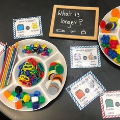 two plates filled with different types of toys on top of a table next to a chalkboard