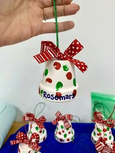 a hand holding a christmas bell ornament with red, white and green polka dots