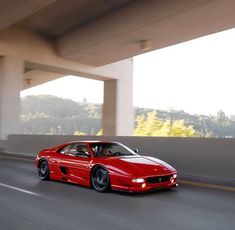 a red sports car driving down the road