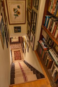 the stairs are lined with books and pictures