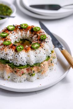 a white plate topped with rice covered in sauce and veggies on top of it