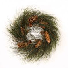 a wreath made out of pine cones and green grass on a white background with clippings