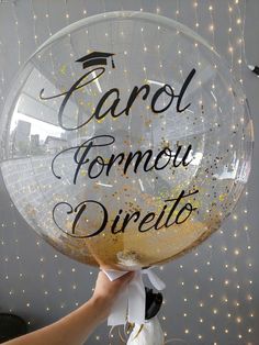 a person holding up a large clear balloon that says carol formou direettoo