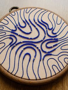 a blue beaded artwork on a wooden hoop