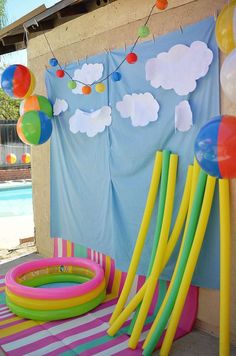 balloons and streamers are hanging on the wall next to an inflatable pool