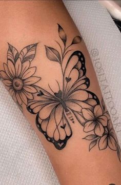 a woman's arm with flowers and butterflies on it