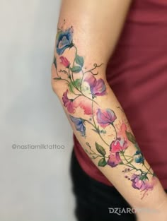 a woman's arm with flowers painted on it