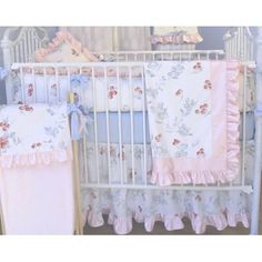 a baby crib with pink and blue bedding