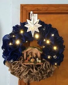 a nativity wreath with lights hanging on the front door, and a star above it