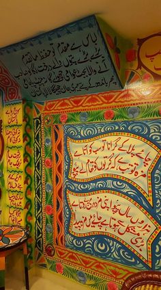 two chairs sitting next to each other in front of a wall with arabic writing on it