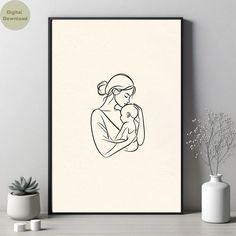 a black and white drawing of a woman holding a baby in her arms on a wall