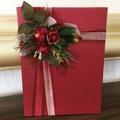 a red box with flowers on it sitting on a table