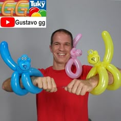 a man holding three balloons in front of his face and smiling at the camera,