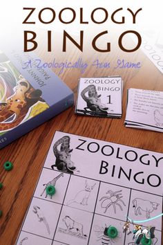 the zoology bingo game is sitting on a table next to two children's books