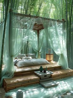 a bed in the middle of a forest with sheer curtains on it's sides