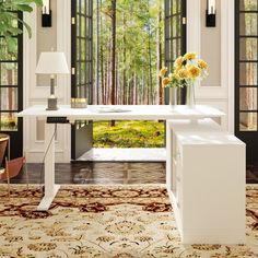 a white desk sitting inside of a living room next to a large open window on top of a wooden floor