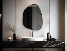 a bathroom with marble counter top and round mirror on the wall above it's sink