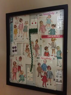 a wall hanging on the side of a wall covered in paper dolls and children's clothes