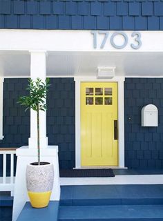 a yellow front door on a blue house