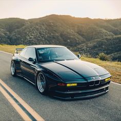 a black sports car driving down the road