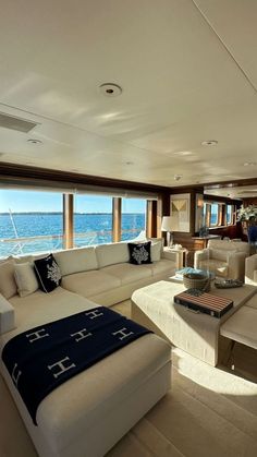 a living room filled with lots of furniture and large windows overlooking the ocean in front of it