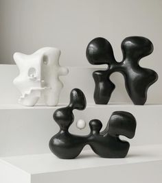 three black and white sculptures sitting on top of each other