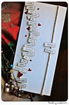 a wedding card with words on it and hearts attached to the front, sitting on top of a table