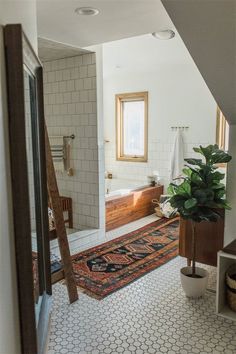 a bathroom with a rug, sink and bathtub next to a ladder in the wall