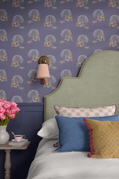 Photo of a bedroom looking straight on at the bed with a large decorative headboard and throw pillows beside a bedside table with a cup of tea and vase of tulips. Horse themed patterned wallpaper on the wall behind. Wallpaper Accent Wall Bedroom, Equestrian Wallpaper, Wanderlust Wallpaper, Hare Wallpaper, Patterned Wallpaper, Inspired Bedroom, Bedroom Wallpaper, Accent Wall Bedroom, Country Interior