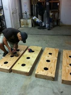 a man working on some wooden boards in a room with other wood planks and tools