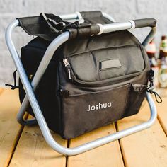 a black cooler bag sitting on top of a wooden table