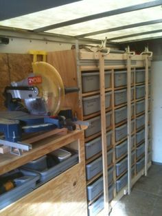 there are many drawers in this garage with tools on the shelves and one has a circular saw