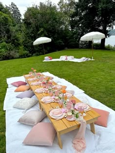 a picnic table set up with pink and white pillows