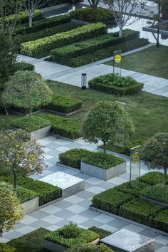 an aerial view of a garden with trees and bushes in the center, surrounded by concrete blocks