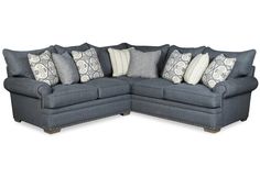 a blue sectional couch with pillows on it