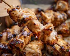 chicken skewers being served with dipping sauce