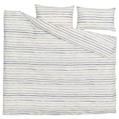 a white and blue striped bed spread with two pillow cases on top of each other