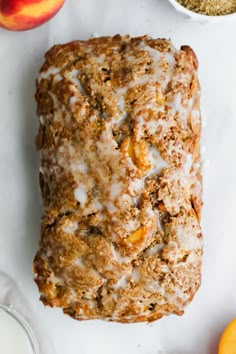 a loaf of bread sitting on top of a table next to some oranges and other fruit