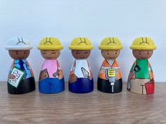 a group of wooden toy figurines wearing hard hats