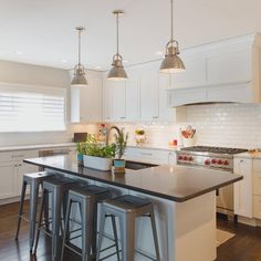 a kitchen with an island and three stools in front of the stove top oven