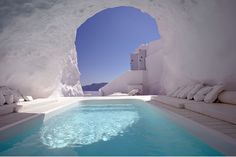 an indoor swimming pool with white walls and blue water