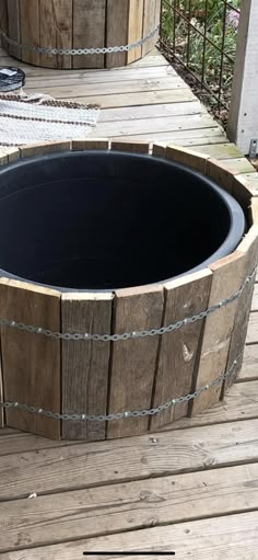 two large wooden barrels sitting on top of a wooden deck next to eachother