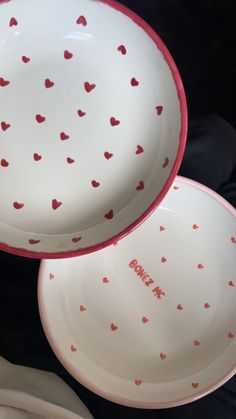 three plates with hearts painted on them sitting next to each other in front of a black background