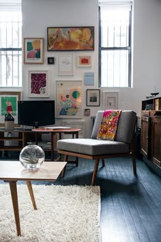 a living room filled with furniture and pictures on the wall above it's windows