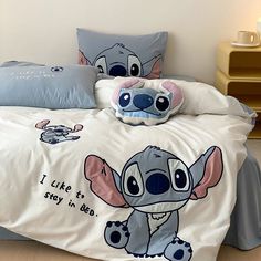 a bed with two pillows on top of it and a stuffed animal in the middle