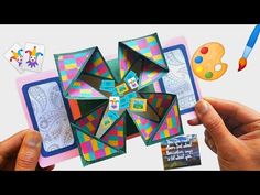 someone is holding up an origami art project with paint and paper on it