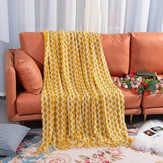 a living room with an orange couch and white curtains