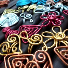 many different colored metal items are on the black tablecloth with gold, red, and blue designs