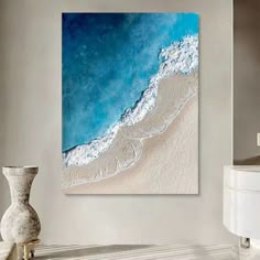 an aerial view of the ocean with waves coming in from the water and white sand on the beach