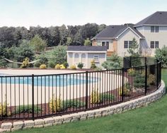 a fenced in pool surrounded by lush green grass